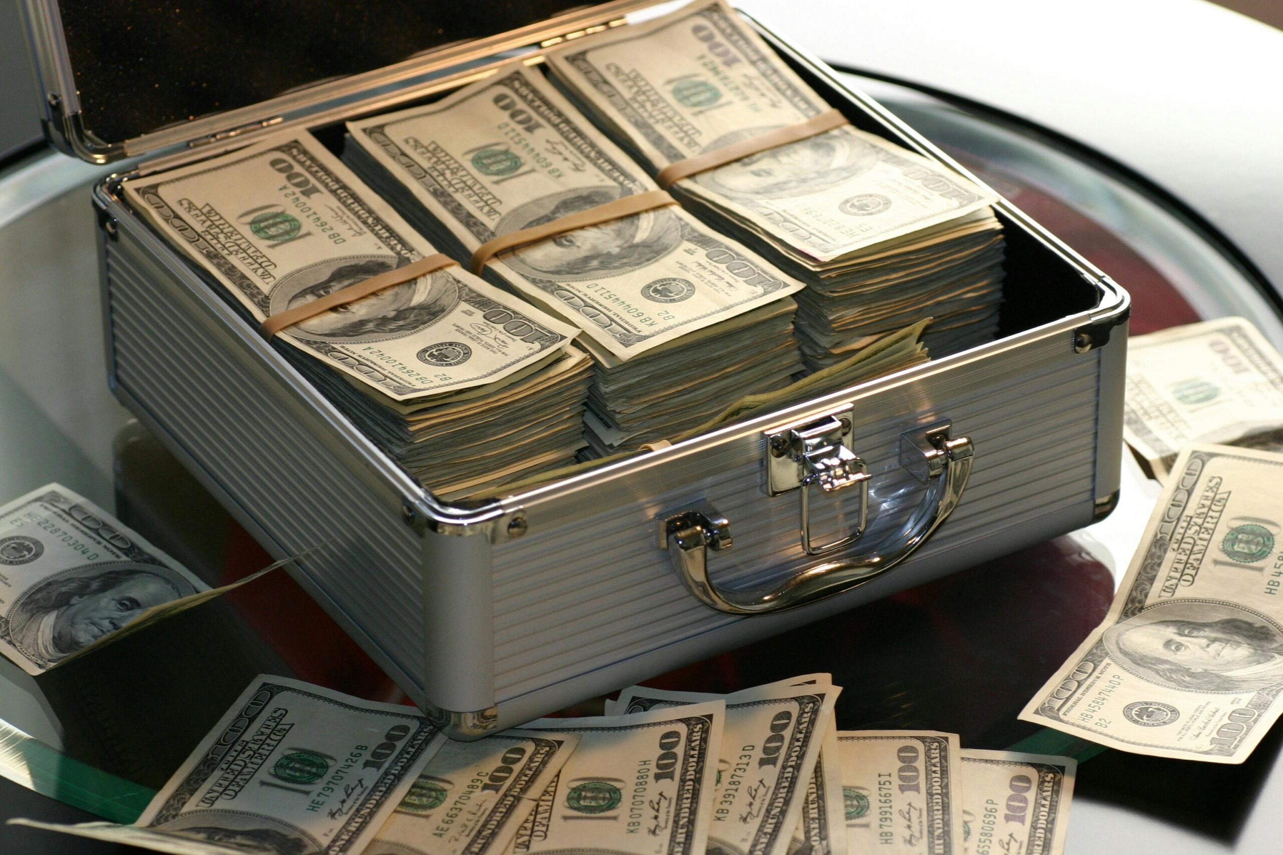 Briefcase filled with us dollar bills, representing the financial industry's potential to benefit from digital human technology and ai-powered solutions for enhanced banking services.